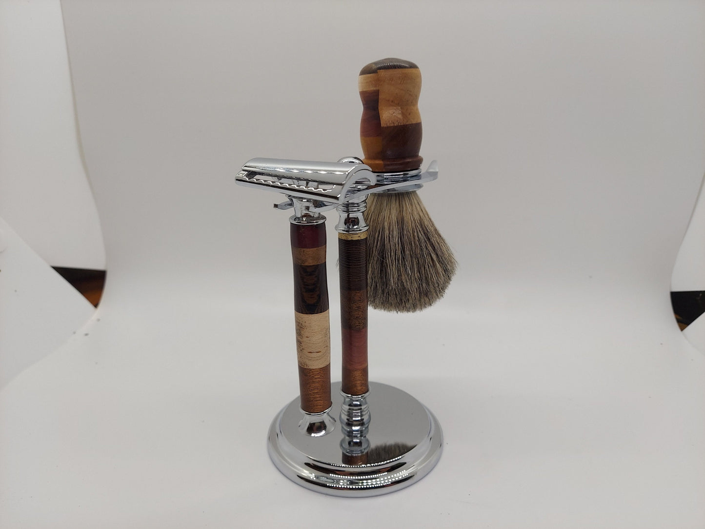 Double edged safety razor set with razor, stand and badger hair brush made from a mix of 11 types of wood