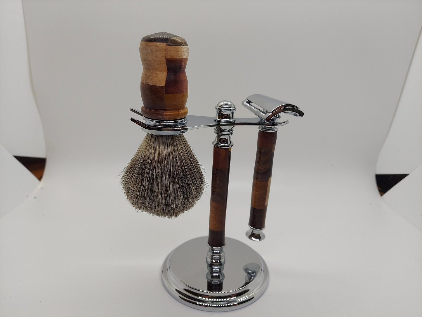 Double edged safety razor set with razor, stand and badger hair brush made from a mix of 11 types of wood